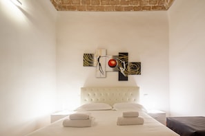 A hotel room with a bed, a headboard, a wall-mounted artwork, and a nightstand. - An apartment for rent with Santa Croce view by Mmega (Firenze)