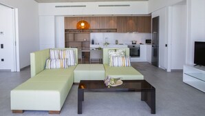 A modern living room with a sofa set, a coffee table, and a kitchen in the background. - Villa Fyki (Lefkada)