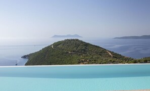 Vista clara de uma piscina ampla e tranquila, com uma montanha ao fundo.