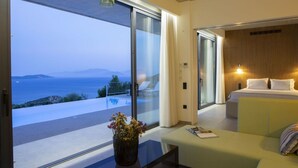 A modern hotel room with a large sliding glass door leading to a balcony with a sea view. - Villa Fyki (Lefkada)