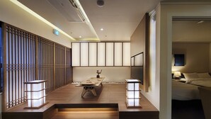 Una habitación de hotel moderna con piso de madera, una mesa central y dos lámparas de noche.