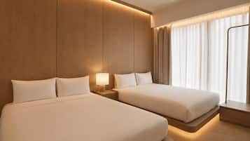 A hotel room with two beds, a nightstand with a lamp, a window with curtains, and a wooden wall panel.