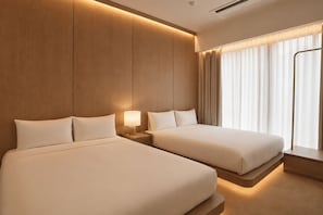 A hotel room with two beds, a nightstand with a lamp, a window with curtains, and a wooden wall panel. - UH Suite The Jongno (Seoul)