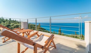 A balcony with wooden loungers and a clear view of the sea. - Villa Ionion Theasis (Lefkada)