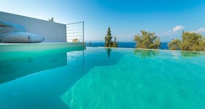 Una piscina al aire libre de temporada, sillones reclinables de piscina