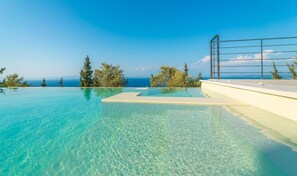 A clear infinity pool with a view of the ocean and distant mountains. - Villa Ionion Theasis (Lefkada)