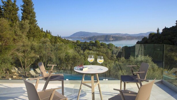 A terrace with a glass balustrade, a round table, and two chairs. - Villa Anticlea (Lefkada)