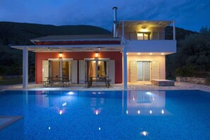 Une maison moderne à deux étages avec une piscine à l’avant.