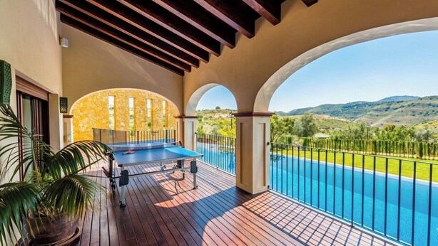 A poolside area with a ping pong table, a view of a swimming pool, and a mountainous landscape. - Mirador del Torcal Antequera by Ruralidays (Málaga)