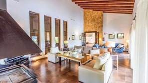 A spacious living area with a fireplace, sofas, a coffee table, and a stone accent wall.