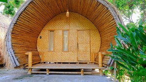 A circular bamboo structure with a bench in front, surrounded by greenery. - OYO 2039 Cici's Bungalow (Senggigi)