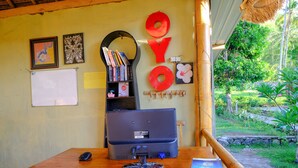 A reception desk with a computer, a phone, and a sign that reads "WELCOME". - OYO 2039 Cici's Bungalow (Senggigi)