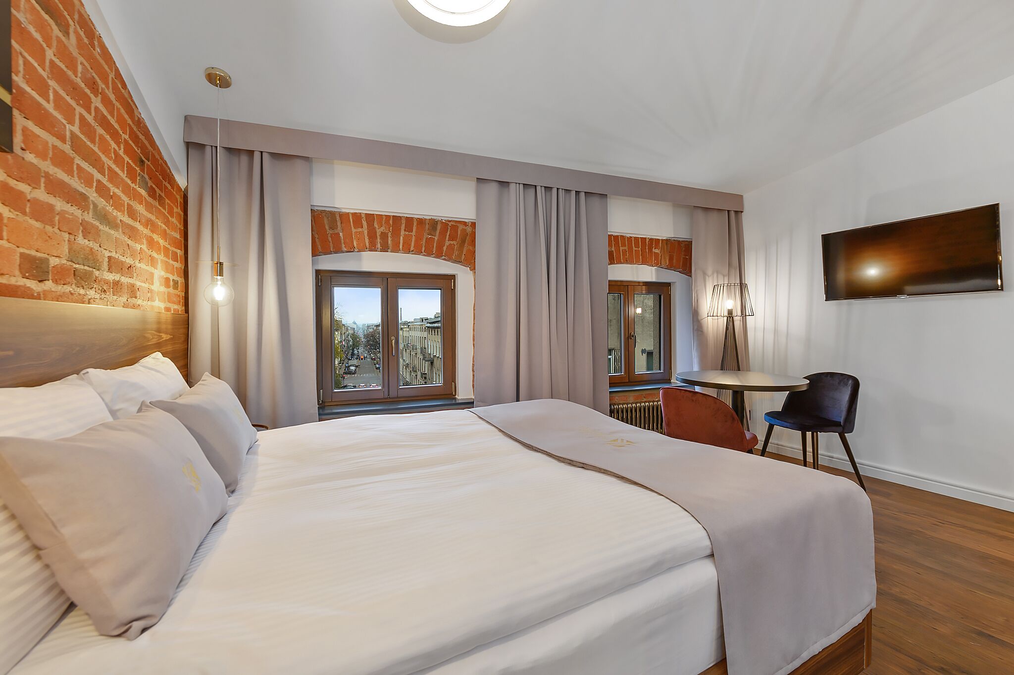 Une chambre d’hôtel avec un grand lit, un bureau et une télévision.