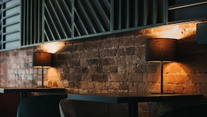 Ein modernes Interieur mit Backsteinwand, Metallstreben und zwei Tischlampen.