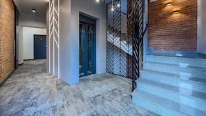 Ein modernes Interieur mit Treppe, Wand mit Muster und Backsteinwand.