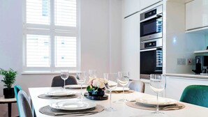 A dining table set with plates, glasses, and a centerpiece.