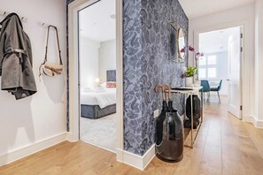 Relax in a serene space with a large bed, comfortable seating area, and a wardrobe with mirror.