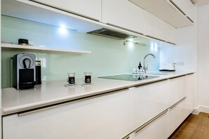 Enjoy cooking in this well-equipped kitchen with a stainless steel range hood, modern faucet, and ample counter space.
