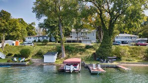 Une propriété au bord du lac, dotée d’un quai, d’un petit abri et d’une maison avec balcon.