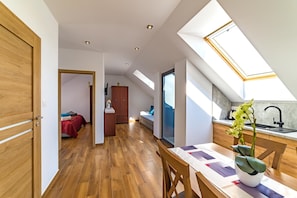 Un appartement moderne de style « loft » comprenant un espace repas, une cuisine et une chambre.