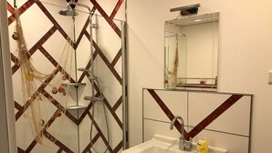 Une salle de bain avec une douche, un lavabo et un miroir.
