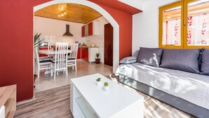 A modern living room with a sofa, a dining area with chairs, and a kitchen in the background. - 3 bedroom gorgeous apartment in Skradin (Skradin)