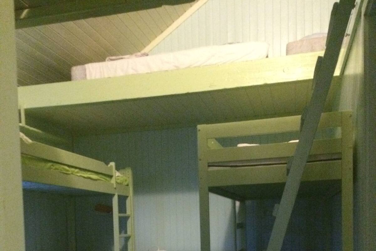Ein Schlafraum mit Etagenbetten, einem Schminktisch und einem Teppich mit Sternenmuster.