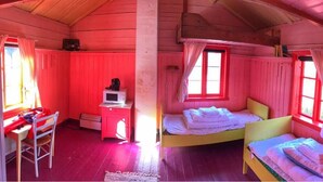 A cabin with two beds, a desk, and a chair. - Lofoten Hostel (Vestvågøy)