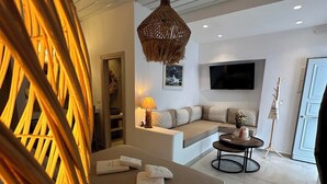 Une chambre à coucher moderne avec un grand lit, un canapé, une petite table et un luminaire suspendu.