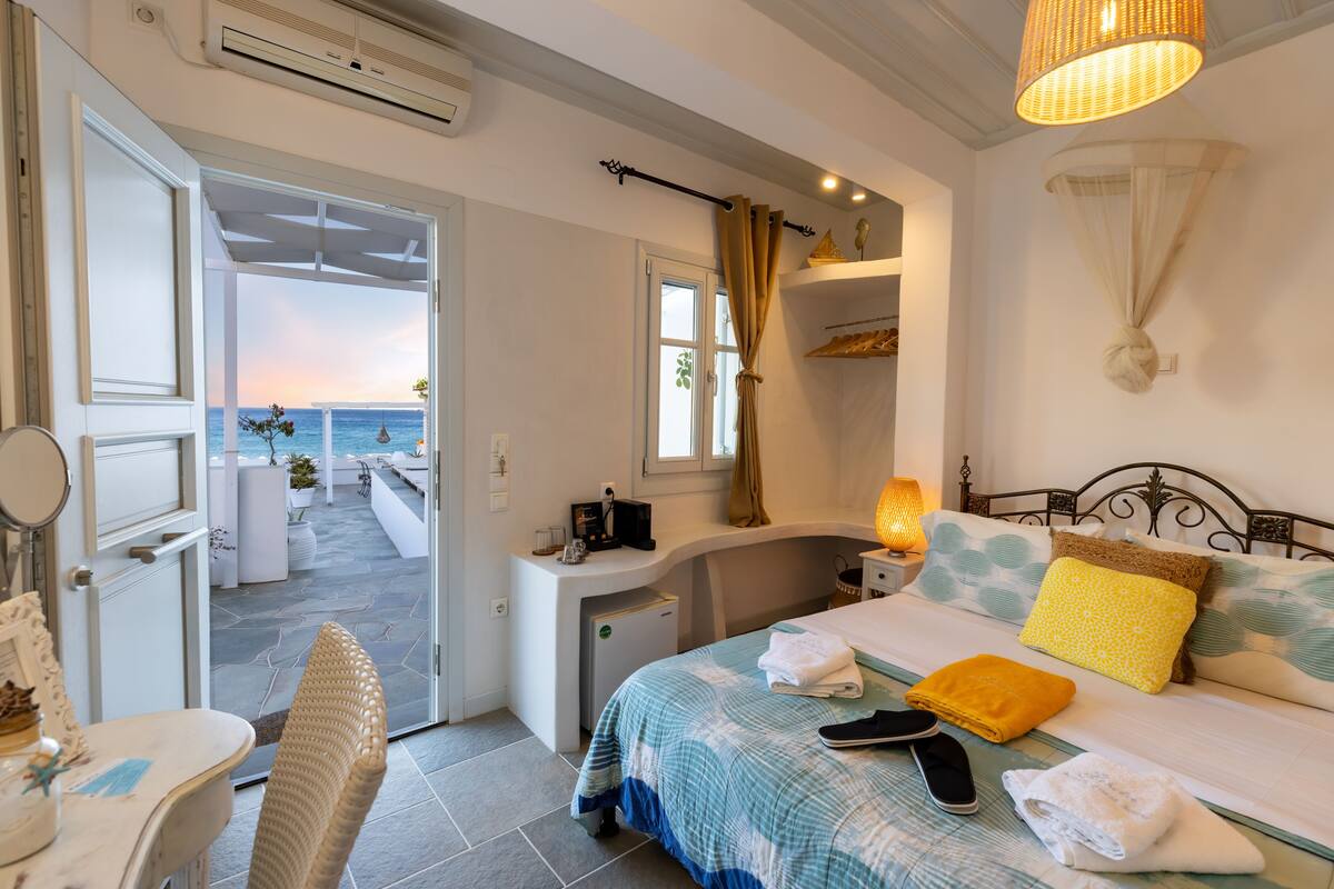 Ein Schlafzimmer mit Bett, Nachttisch und Meerblick.