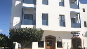 Un edificio de varios pisos con balcones, una entrada central y un letrero que dice "Residencia Gorda".