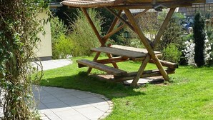 A wooden picnic shelter with a sloped roof and two benches. - Cozy apartment 6 (Zeulenroda-Triebes)