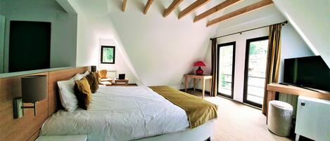 Un dormitorio con cama, escritorio, televisión y ventana.
