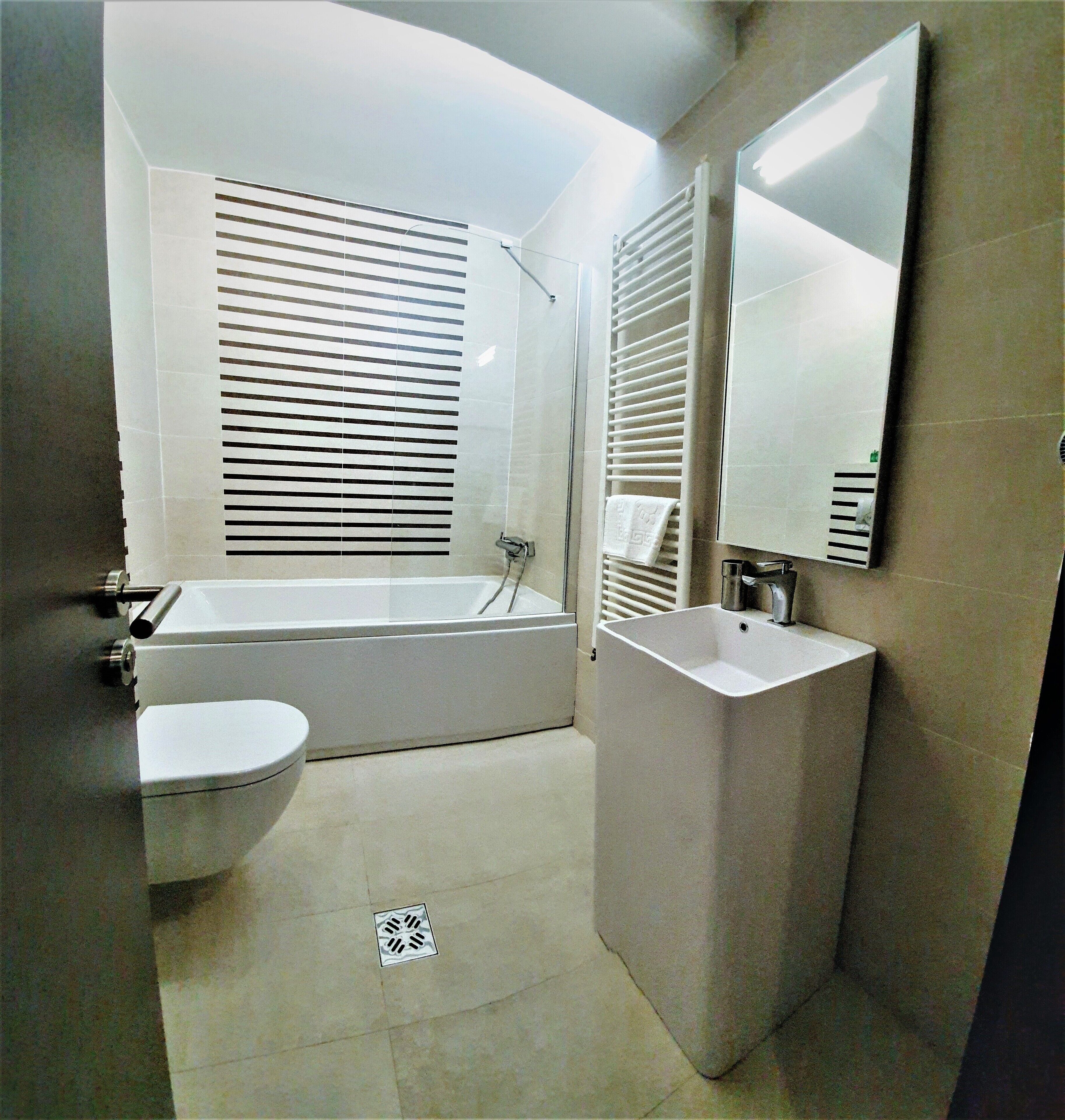 A modern bathroom with a bathtub, toilet, and sink.