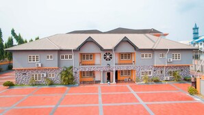 A two-story building with a symmetrical facade, large windows, and a central entrance. - First B&R Hotel (Uyo)