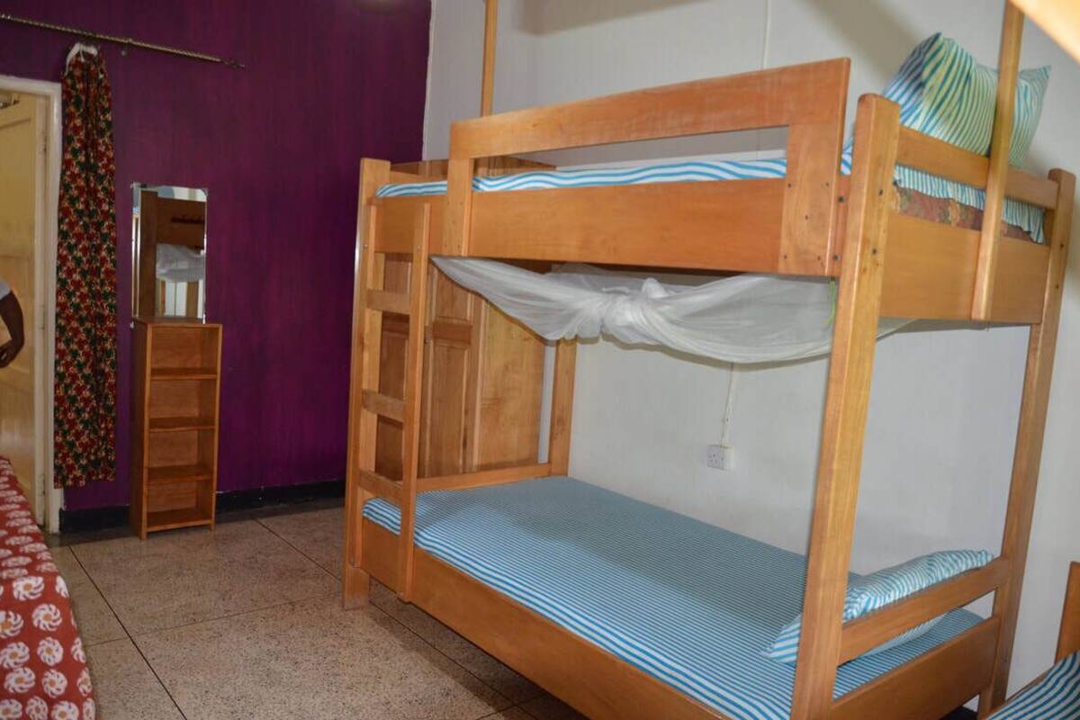 Un lit superposé avec une structure en bois et une literie à rayures bleues.