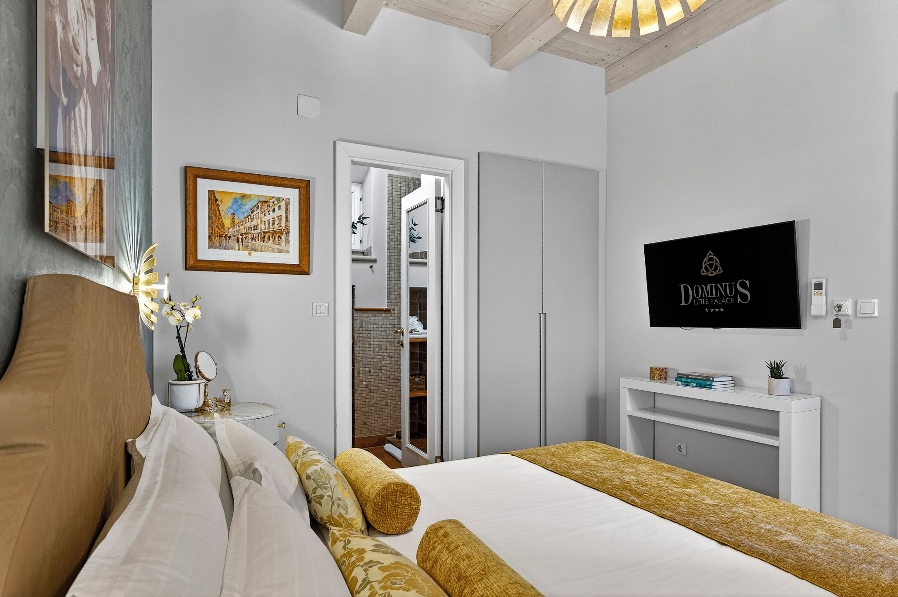 Ein Hotelzimmer mit Bett, Fernseher, Schreibtisch und Kleiderschrank.