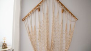 A macrame wall hanging with a wooden frame and multiple cords. - At sea level, and overlooking the beach.  Apartment with terrace and 8 hrs of sun (Porís de Abona)