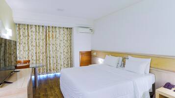 Une chambre d’hôtel équipée d’un lit, d’un bureau, d’une chaise, d’un téléphone et d’un appareil de climatisation.