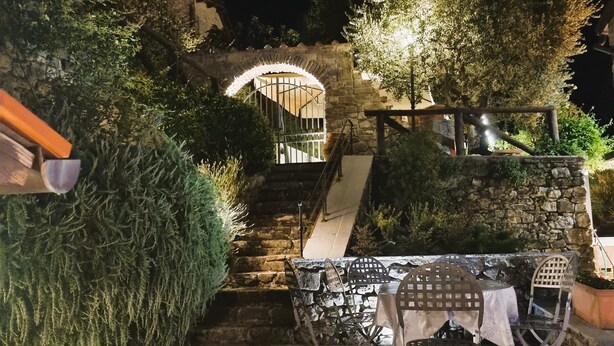 A stone staircase leading to a covered area with outdoor seating. - Costola, private pool, stunning mountain views. Chef on request. (Fosciandora)
