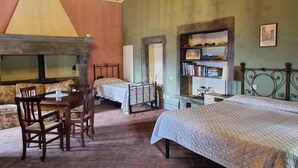 A bedroom with two beds, a wooden table with chairs, a bookshelf, and a chandelier. - Costola, private pool, stunning mountain views. Chef on request. (Fosciandora)