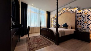A four-poster bed with a patterned headboard, a desk with a chair, and a large window with sheer curtains. - Holiday Villa Hail Hotel (Ha'il)