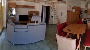 A compact living space with a kitchenette, a dining area, and a seating area. - Adler Gaststube Hotel Biergarten (Bad Rappenau)