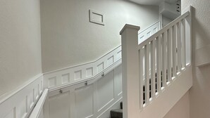 Eine Treppe mit weißer Handläufe und einem Bilderrahmen an der Wand.