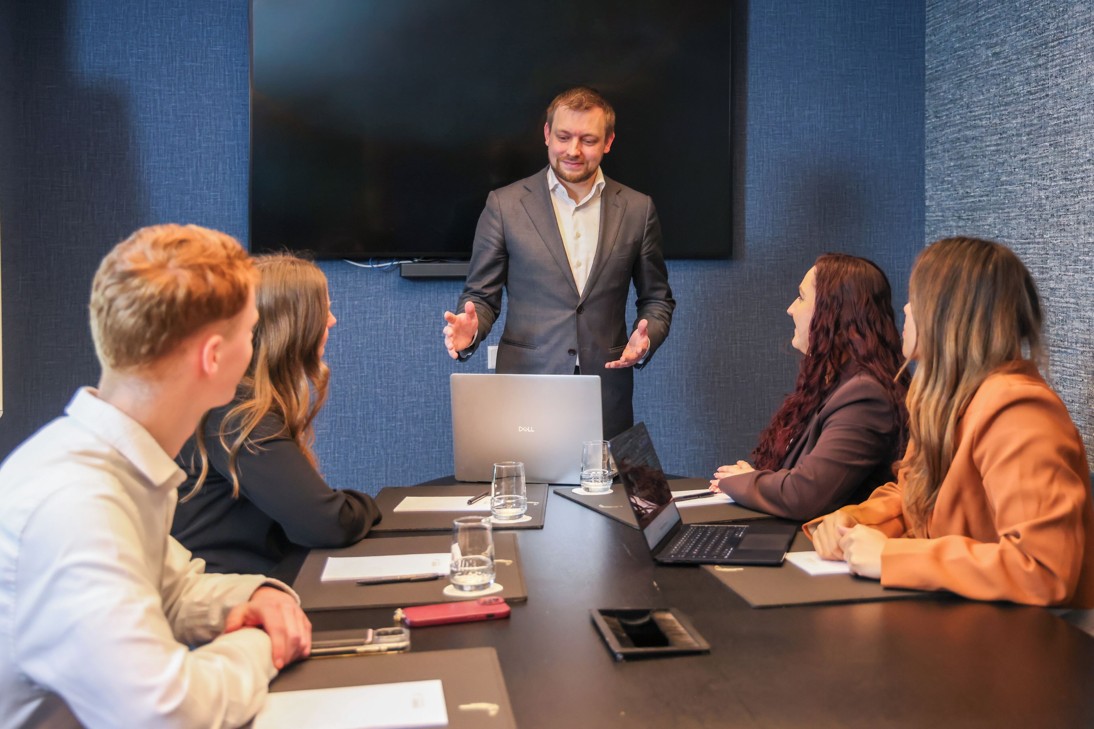 Ein Konferenzraum mit Präsentationsausstattung, darunter ein Laptop, ein Lautsprecher und ein Bildschirm.