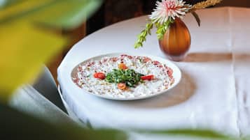 A plate of food on a table with a vase of flowers.
