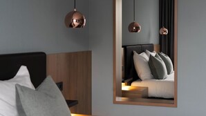 A modern hotel room with a wooden headboard, a bed with white and grey bedding, and two pendant lights. - Van der Valk Hotel Gorinchem-A27 (Gorinchem)
