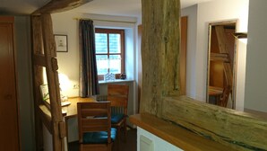 A wooden-framed room with a window, a chair, and a table. - Pension Landhaus Fischer (Massweiler)