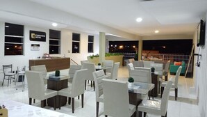 Vestíbulo de hotel con recepción, zona de estar y vistas al exterior.