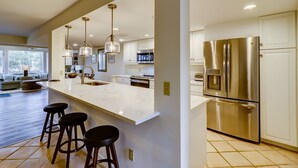 A modern kitchen with a large island, stainless steel appliances, and pendant lighting. - 1421 South Beach Villa is a beachy 4 bedroom, 3 bath townhome (Hilton Head Island)